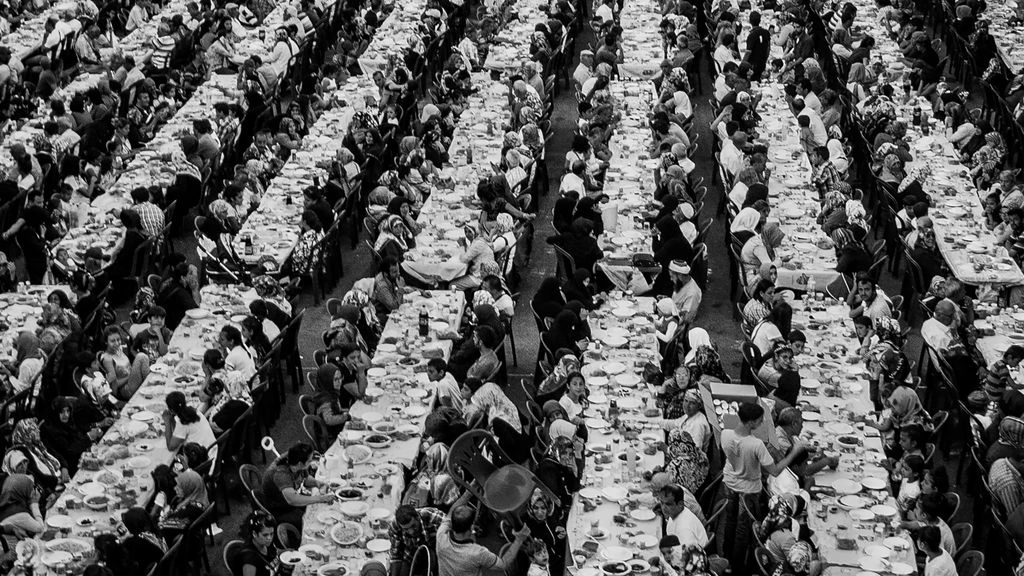 A long banquet table dressed with Bavarian porcelain in a softly lit alpine dining room.