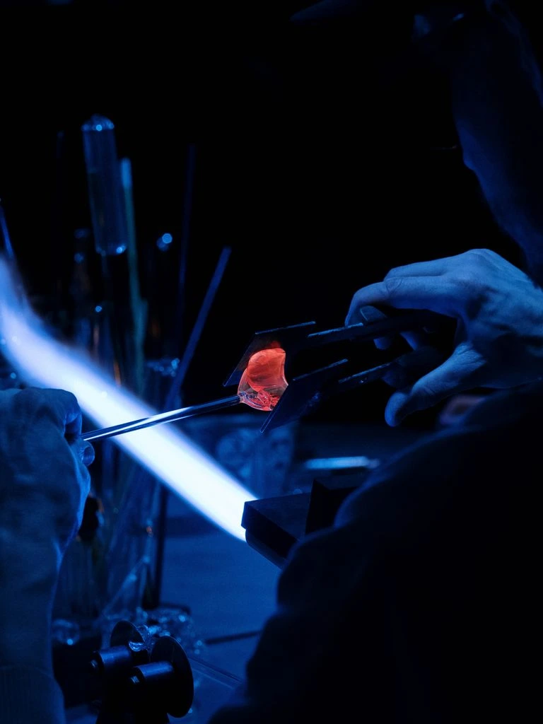 Master glassblower at Glashütte Auer forming a mouth-blown decanter.
